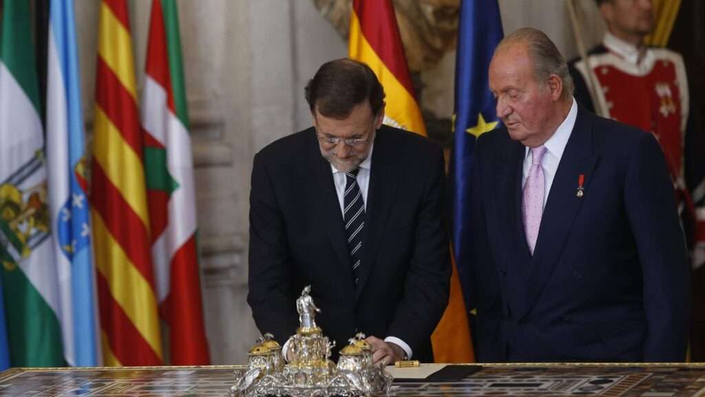 El Rey Juan Carlos I refrenda la ley orgánica de abdicación junto al entonces presidente del Gobierno Mariano Rajoy